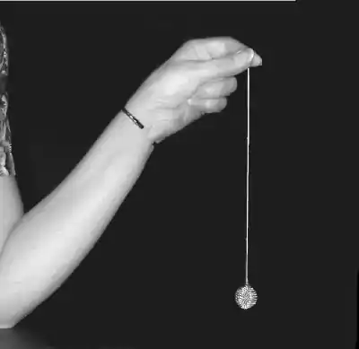 arm and hand holding Chevreul pendulum